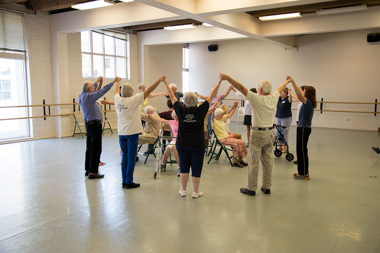 Dancers holding joined hands overhead