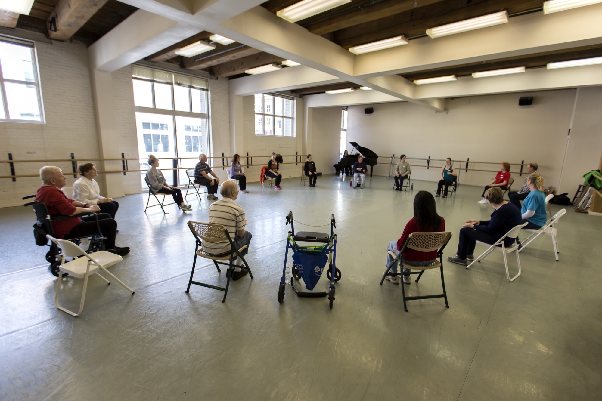 A welcoming circle of dancers in a light-filled Boise studio with grand piano