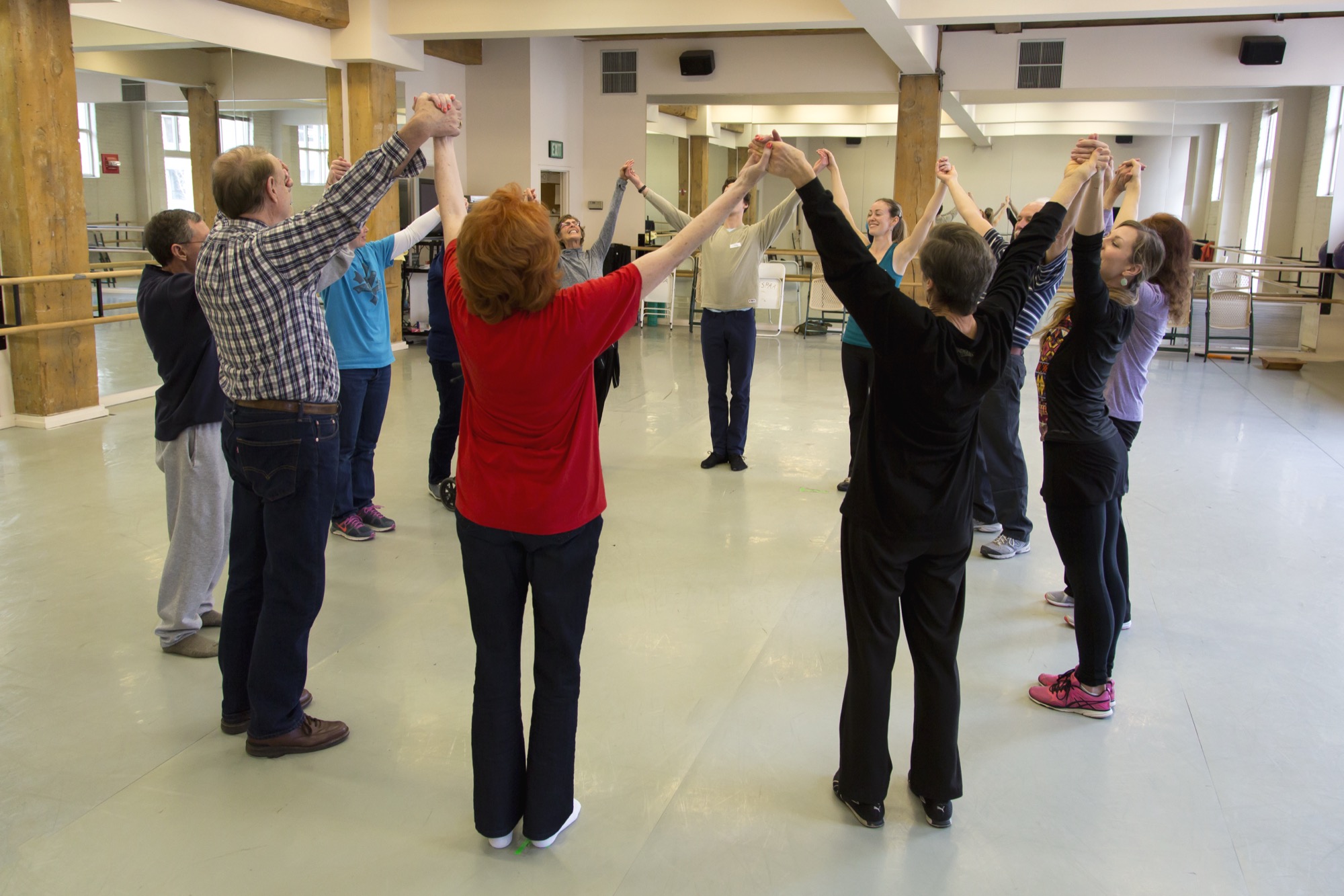 Dancers lifting joined hands overhead in celebration